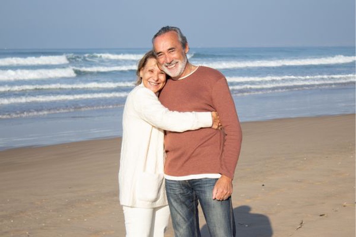 Pareja de adultos mayores disfrutando juntos en la playa