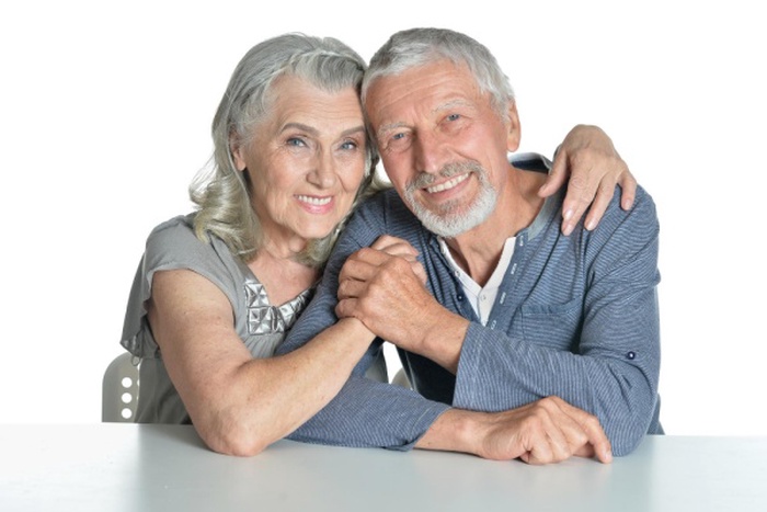  Portrait of hugging senior couple sitting at table