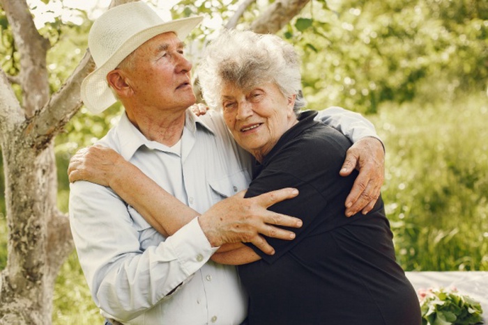 Beautiful old couple spend time in a summer garden