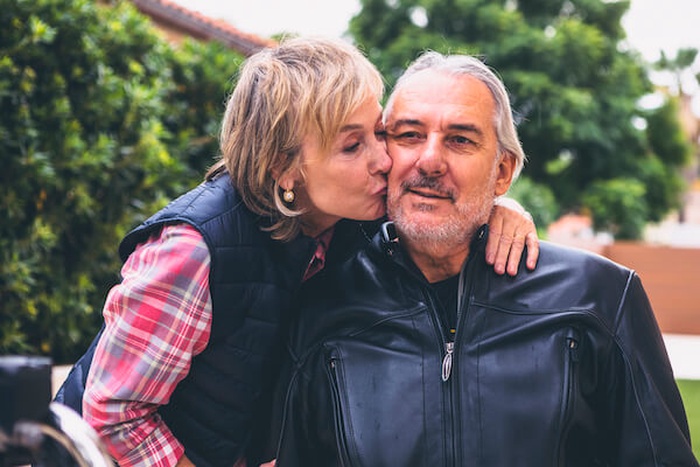 mature woman kissing man cheek