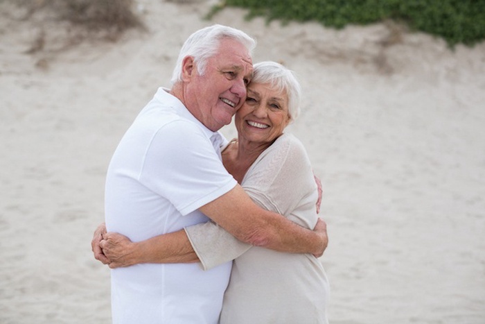 Senior couple embracing each other on the beach