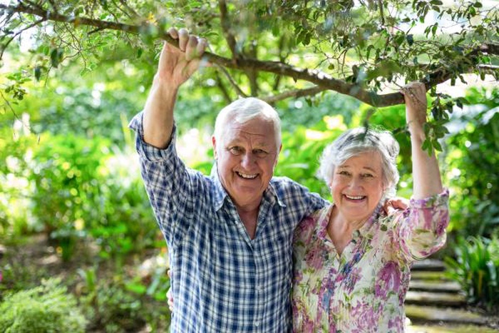 Cheerful senior couple smiling while enjoying time together in a green garden