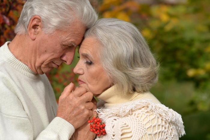 Closeup portrait of sad senior couple in autumn park