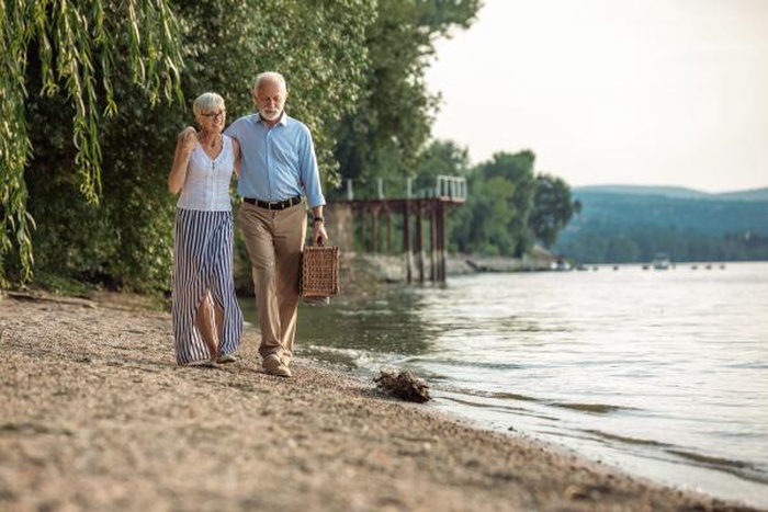  senior couple going on a picnic at the riverbank