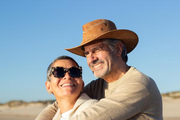 Senior couple smiling together on sunny beach