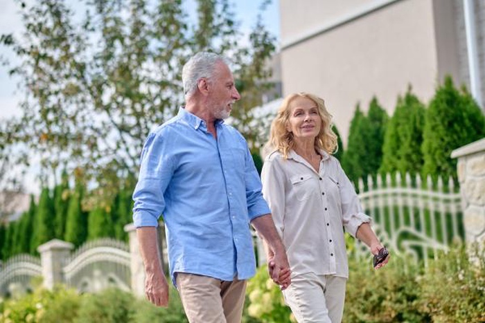 A happy senior couple walking in the street hand in hand