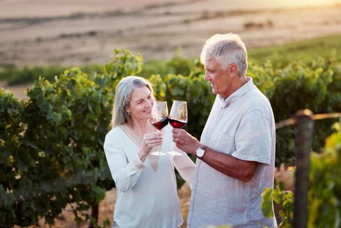 An elderly couple celebrates wonderful moments together in a vineyard