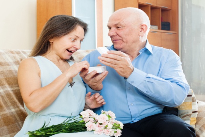 Man presenting surprised woman jewel