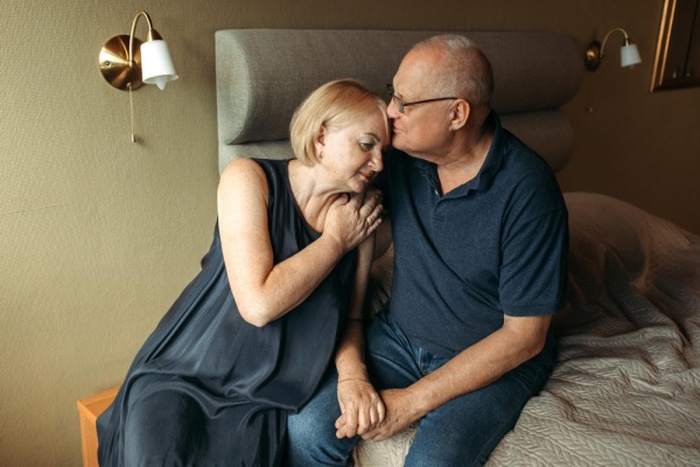 Happy elderly couple an elderly woman strokes her husband's hand gently presses against him