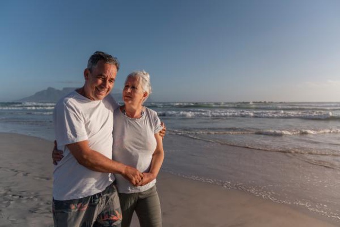 A senior couple strolls along the seaside