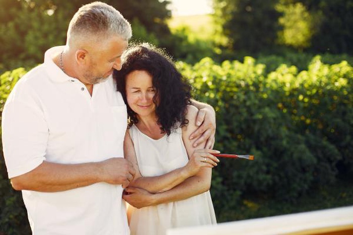 Beautiful adult couple drawing in a summer field