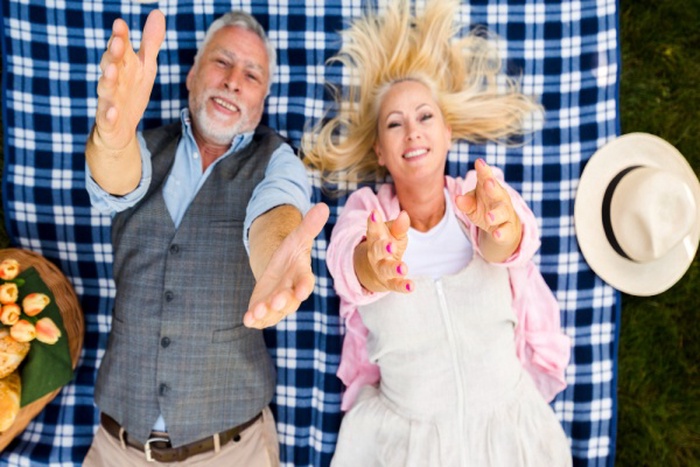  Old couple raising their arms to camera top view