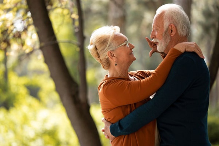 Medium shot senior couple holding each other