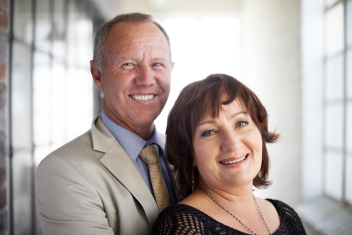 Love hug and portrait of mature couple in real estate agency for partnership consultants and entrepreneur venture smile teamwork and collaboration with senior man and woman in startup company