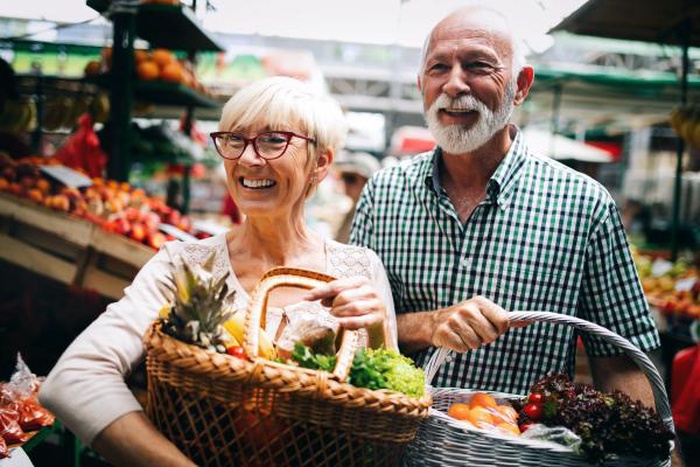 Happy mature senior couple shopping fresh produce at farmers market, over 50 dating daily lifestyle