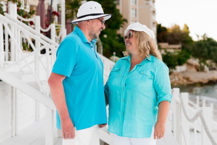 Side view of elder tourist couple on the beach