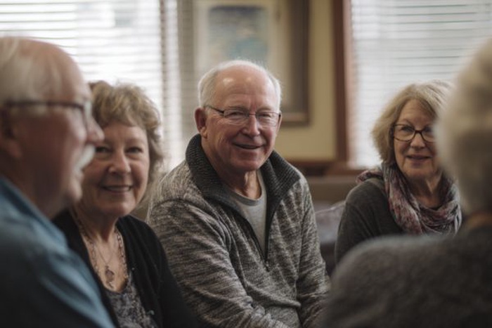 Senior empty nesters chatting together in a cozy community room.