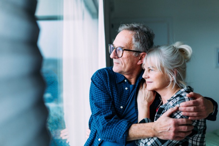 Elderly couple in retirement home looking out of window