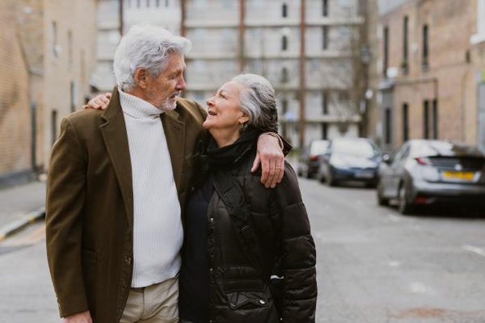 Senior couple sharing a tender moment walking together on a city street date