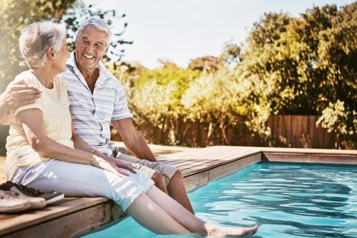 Senior couple hug and relax by swimming pool for love