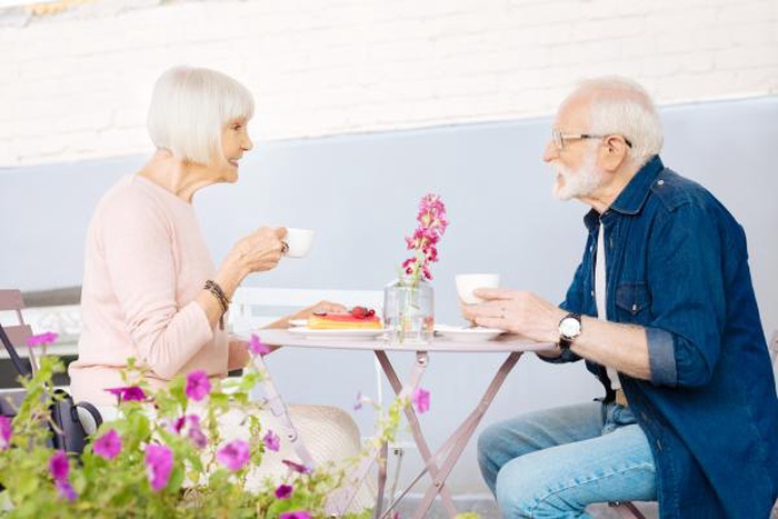 Charming senior couple sitting at cafe and delighting coffee