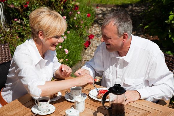 A senior couple drinking coffee in the garden