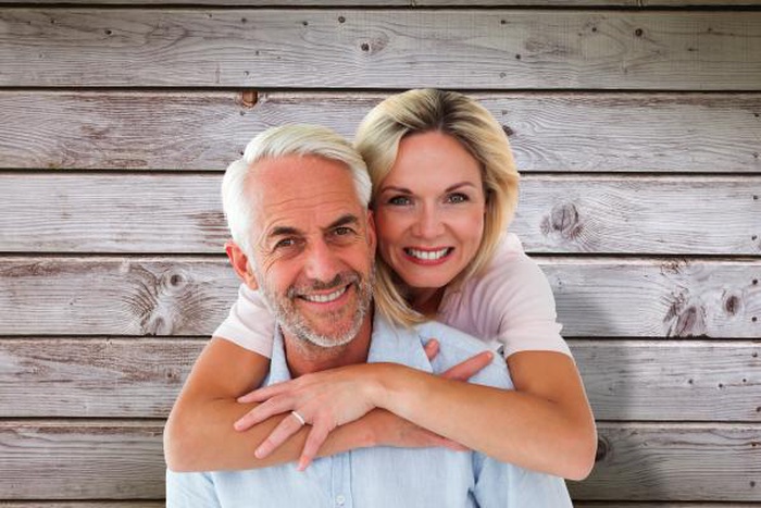 Senior woman embracing her partner from behind