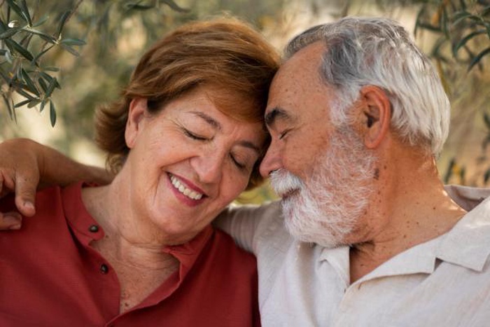 Elderly couple holding hands in park