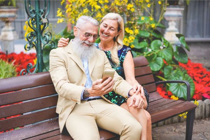 Two seniors on a date sitting together on a park bench in Haverford, Pennsylvania