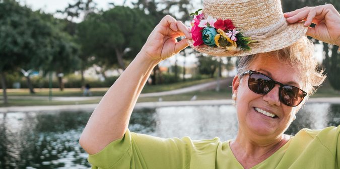 Portrait of smiling retired woman wearing a hat