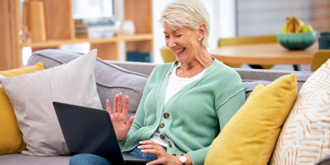 Senior woman smiling using laptop for online dating