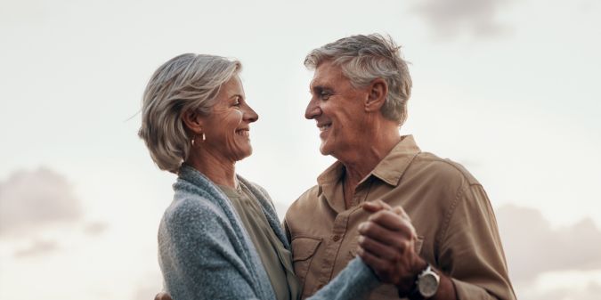 Happy senior couple dancing, symbolizing mature relationship joy.
