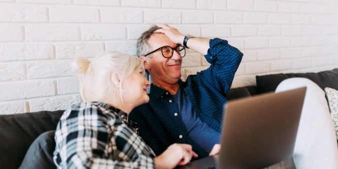 Senior couple laughing together online