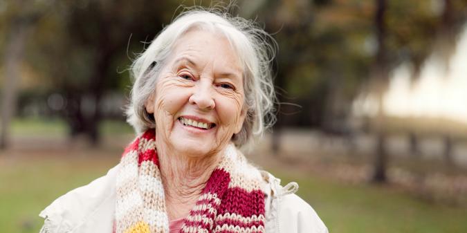 Senior woman smiling confidently outdoors feeling well