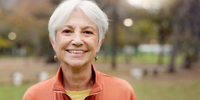 Confident senior woman smiling feeling attractive outdoors