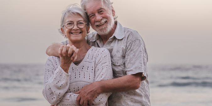 Two elderly men with white hair were hugging each other.