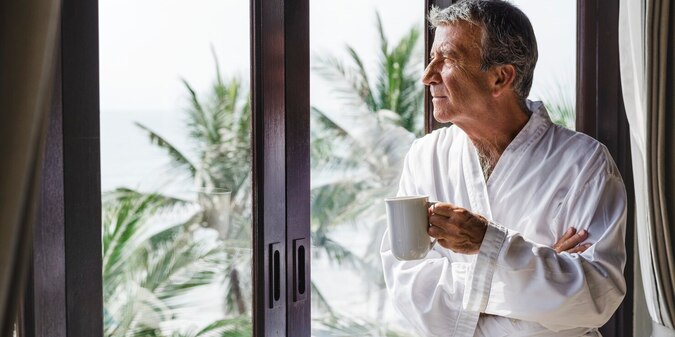 Mature man looking out the hotel window