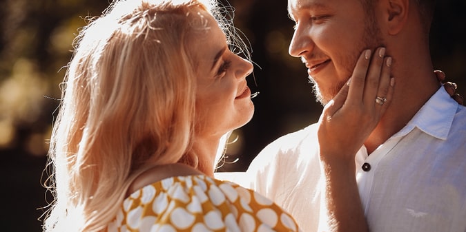 Man and beautiful woman in yellow dress hug each other tender