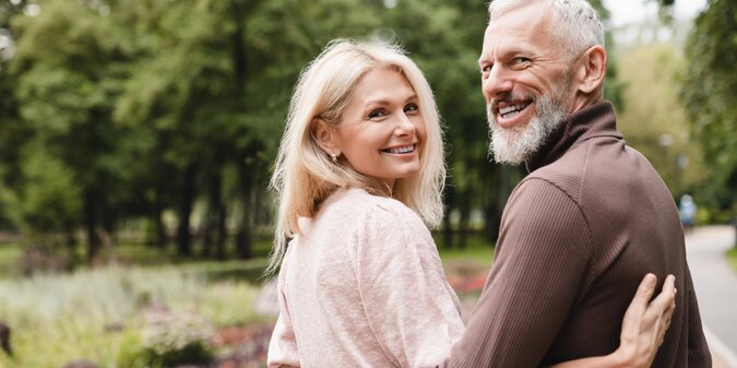 Smiling happy caucasian mature spouses hugging embracing