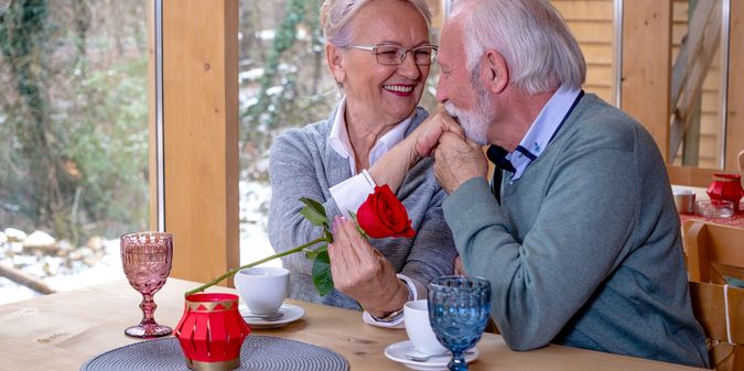 A gentleman with a rose, kissing his wife