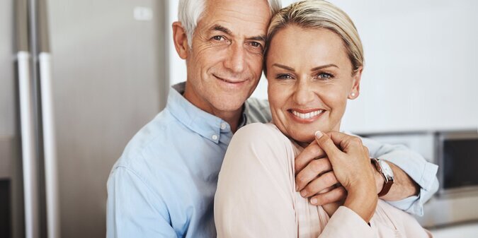 Mature couple face and hug in home