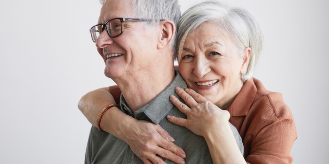 senior couple embracing and looking at camera