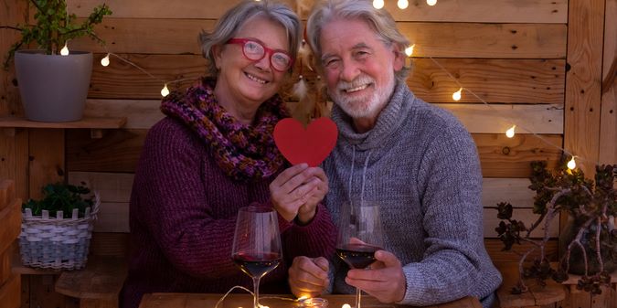 smiling romantic senior couple at table