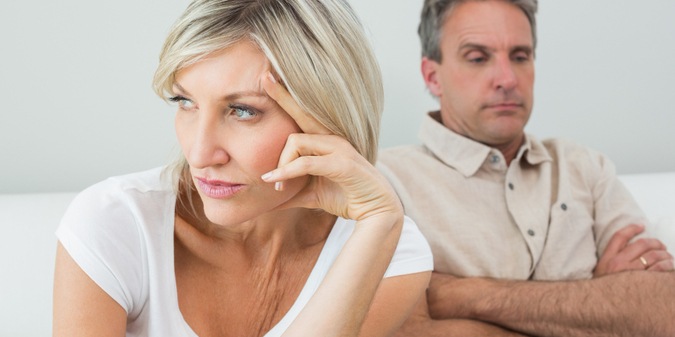 Angry couple sitting on sofa after a fight
