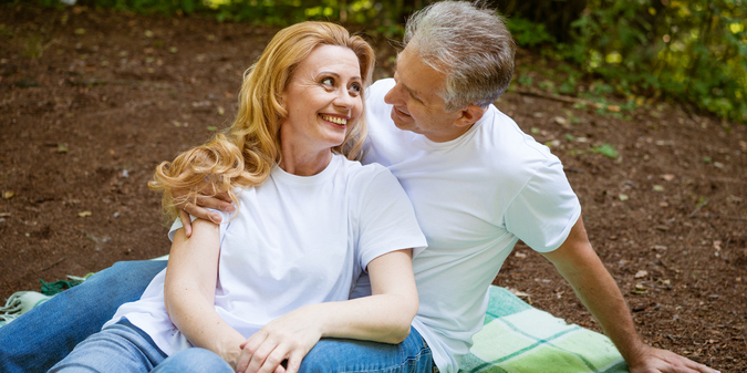 mature-adult-happy-couple-park-hugging-while-sitting