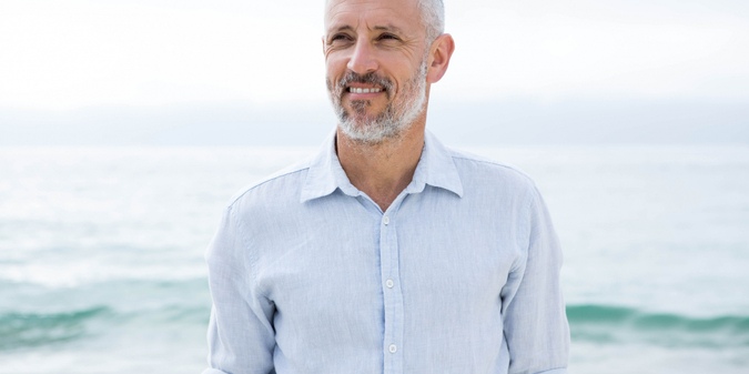 Smiling man standing by the sea