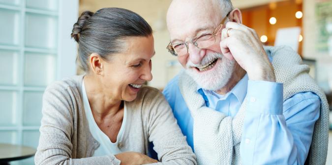 Senior couple smiling warmly on a first date