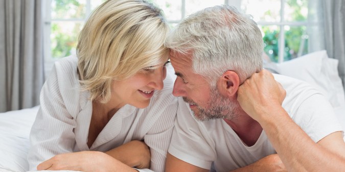 a mature couple lying in bed