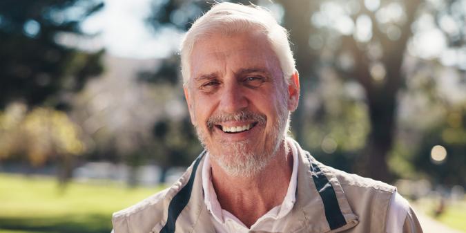 Confident senior man smiling outdoors at 65
