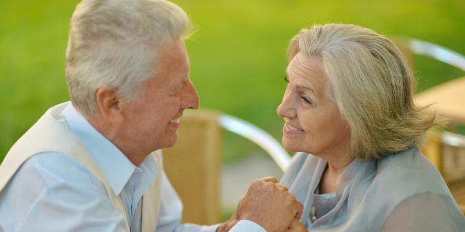 Senior couple holding hands smiling at each other